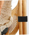Black easy-install clamp on rattan chair with hand showing stability. Outdoor Sectional Sofa Clips 4 Pack For Patio Furniture.