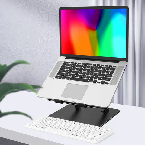 Adjustable Laptop Stand for Desk, Foldable Riser Holder With Ventilated Cooling elevating a laptop beside a plant