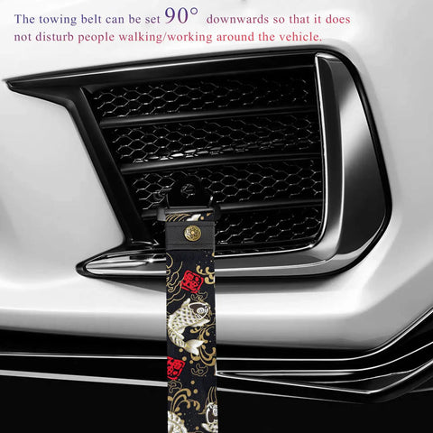 Sick JDM Koi Fish Racing Tow Strap mounted on car bumper, featuring heavy gauge nylon material and brass buckle.
