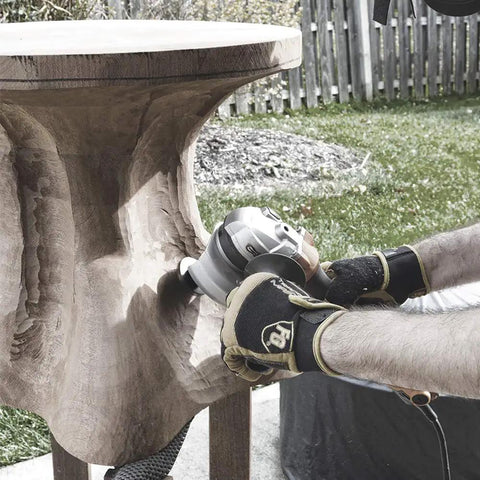 A craftsman using a Heavy Duty Mini Turbo Angle Grinder Kit With 50 Millimeter Tungsten Cutters for detailed wood sculpting.