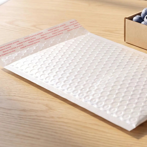 White Bubble Mailers 30 Pack 6x8 Inch Padded Envelopes For Small Biz Shipping laid on wooden table with self-seal feature visible