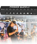 Eight Isolated Outputs Pedalboard Power Supply with independent short circuit protection overlaying a live music gig scene