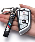 Hand holding BMW M Keyring And 4 Pack Dope Valve Stem Caps Car Keychain Set For M2 M4 M5 M6 M8 X1 X2 X3 X5 X6 M135i M240i