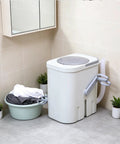 Hand Crank Washing Machine With Biomimetic Scrub Interior Manual Portable Laundry Soaker in bathroom next to laundry basket.