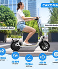 Woman riding Peak 800W Electric Scooter with seat for adults, white, showing 12-inch tires and detachable basket, urban setting.