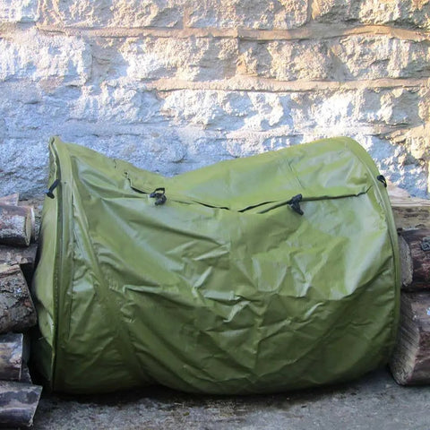 Roll Mix Compost Bin Tumbler For Home Garden Green 41 Gallon Capacity 26 Inches Wide next to stone wall