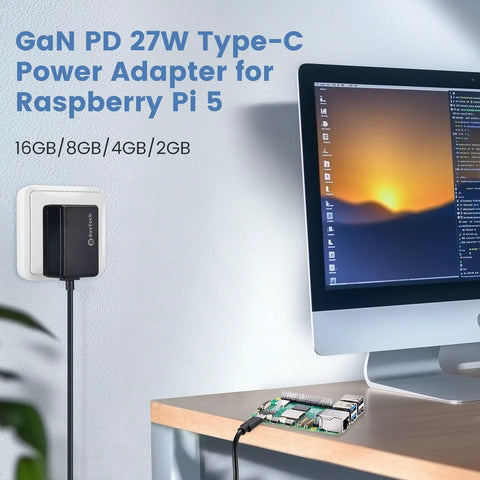 Beefy GaN 27W USB C PD Power Adapter For Raspberry Pi 5 Five Point One Volt Five Amp Charger With 130 Centimeter Cable And 100 240V AC Input Built To Power Pi 5 And Peripherals Across 16GB 8GB 4GB And 2GB RAM Models, shown installed on a wall near a desk with Raspberry Pi