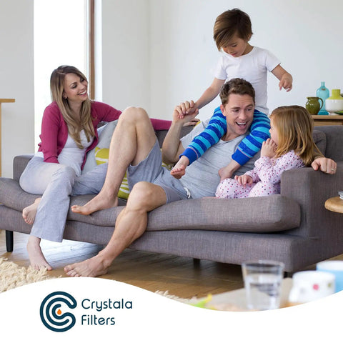 Family relaxing on couch in living room with Crystala Filters branding visible