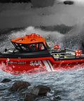 Red and black SAR remote control rescue boat on water near waterfall, resembling RC Jet Boat Remote Control Watercraft For Lake Or Pool Top Speed 8 Kmh 1 By 12 Scale 2.4Ghz 4CH Beginner Friendly RTR Easy Handling Strong Tow Power Durable Black Jet Boat.