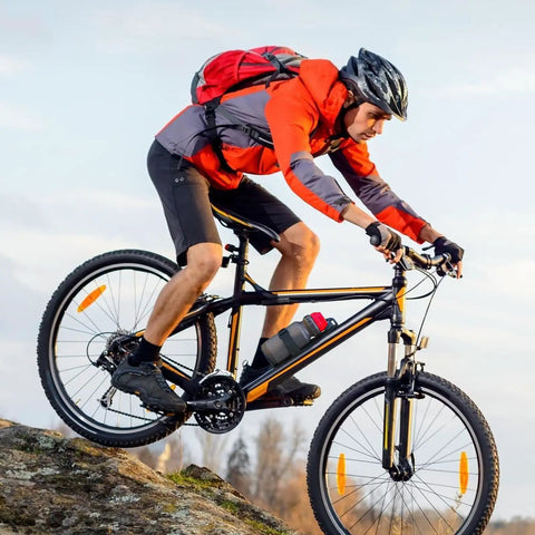 Cyclist using Front Fork Mounted Water Bottle Cage And Cargo Rack For Bikes - Durable Bike Front Rack With Fixing Strap on mountain trail