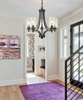 Contemporary Black 5 Light Glass Chandelier For Dining Room And Kitchen Island Farmhouse Style Ceiling Pendant Light with clear glass shades in a modern entryway.