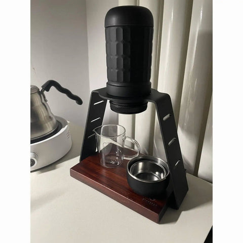Straight Up Solid Coffee Stand And Dripper Holder Built With Heavy Duty Carbon Steel And Wooden Pedestal Base For Clean Manual Brew Organization That Stays Crisp, featuring a glass server, metal cup, and brewing station.