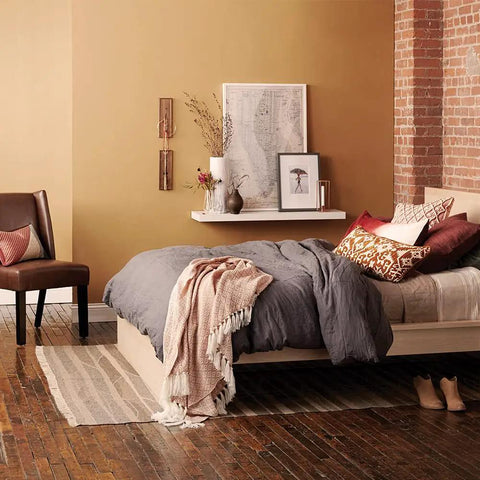 Cozy bedroom with brown tones, modern decor, gray bedding, and wooden floor