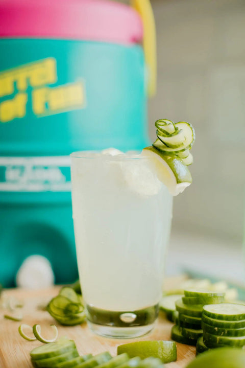 Close-up of a Retro 2 Gallon Party Water Jug Cooler Jade Finish With Eco Friendly THERMECOOL Foam Insulation, next to a drink.
