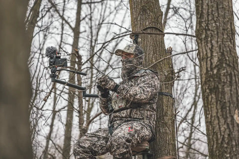 Hunter using Stiff Arm Tree Camera Arm Mount, Lightweight Aluminum With 360 Tool-Less Leveling in forest setting