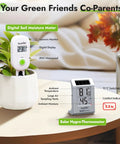 Light Driven Thermo Hygrometer And Smart Digital Wireless Soil Moisture Meter Kit with sensors on table with plant