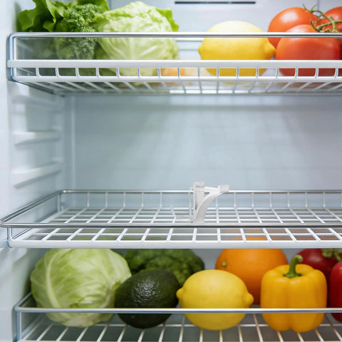 Image of 8 Pack Aluminum Shelf Clips for Fridge and Freezer on a refrigerator shelf with vegetables, showcasing smooth surface and durability.