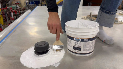 Applying Heavy Duty Silicone Roof Patch Kit 2 Gallon Black with a brush on a surface for waterproofing.