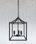 Dope Three Light Industrial Farmhouse Chandelier In Matte Black With Square Cage Pendant Against White Brick Wall