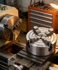 Top Shelf Four Jaw Lathe Chuck 125 Millimeter Single Movement Rig Built Tough With Heavy Alloy on machine table for metalworking.