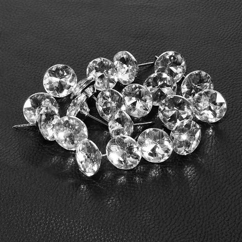 A Total Knockout Thirty Piece Set Of Twenty Five Millimeter Diamond Crystal Upholstery Tacks With Silver Plated Nails displayed on black leather.