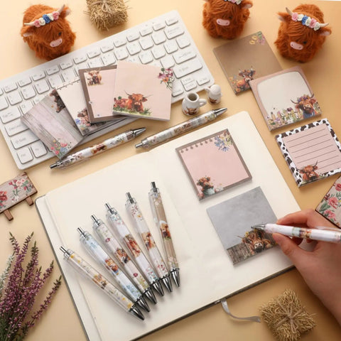 Highland Cow Desk Accessories Set With 9 Cute Sticky Notes And 9 Totally Cute Kawaii Pens 3x3 Inch Notepads on a desk.