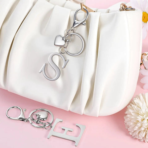 Custom Initial V Keychain In Stainless Steel Key Ring Silver Alphabet Charm For Women And Men shown with purse and accessories.
