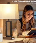Set Of 2 Modern Bedside Lamps With USB Ports And AC Outlet 23.5 Inch Tall Wood Base With Linen Shade next to a girl reading in bed