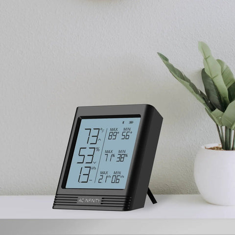 Smart Temp Humidity VPD Hygrometer B2 With LCD Display on shelf, showing temperature and humidity readings.