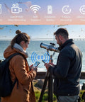 Two people using a 64GB Digital Eyepiece Telescope Camera with 2K HD Video and WiFi for easy setup on a scenic coastline.
