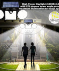 Lit Dual Head Solar Motion Lights Outdoor 260 LED IP65 Waterproof illuminating garden pathway, two people walking at night.