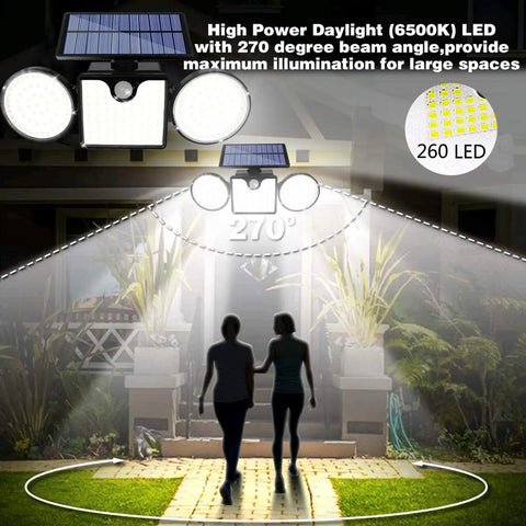 Lit Dual Head Solar Motion Lights Outdoor 260 LED IP65 Waterproof illuminating garden pathway, two people walking at night.