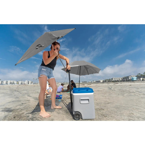 Woman adjusting Versa-Brella SPF 50+ Adjustable Umbrella With Universal Clamp on cart at beach for sun protection, regular size gray.
