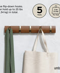 Flip Wall Mounted Coat Rack With Retractable Hooks in use holding a green scarf and beige bag in Light Walnut and Gold.