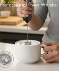 Usb Rechargeable Milk Frother Handheld 2 In 1 Dual Spring Whisk Electric Frother Wand creating foam in a white mug on a kitchen counter