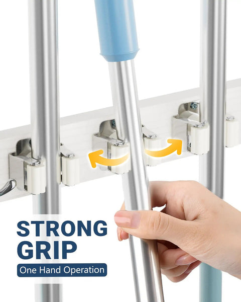 Close-up of Over The Door Broom And Mop Holder With 4 Slots And 4 Hooks, showing strong grip with hand placing a mop.