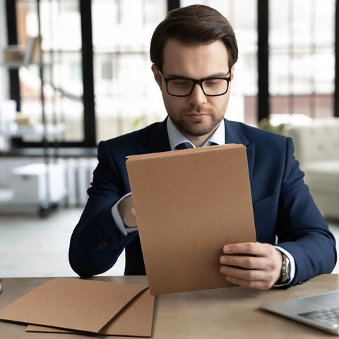 Man holding 7x9 Inch Rigid Kraft Mailers Self Adhesive Flat Shipping Bags 200 Pack Bulk for Office Mailing Documents