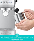 Hands using milk frother on Essential Espresso Machine With 20 Bar Pressure, Stainless Steel Build, Milk Frother For Home Use, Brew Barista Grade Lattes And Cappuccinos, And More, 43.9oz Water Tank, Sleek Silver Coffee Maker