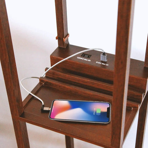 Charging area of Maxwell Charger Shelf Floor Lamp with USB Ports and Electrical Outlet in Havana Brown with smartphone charging.