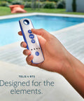 Person holding Telis 4 RTS Patio Remote 5 Channel Replacement For Outdoor Blinds And Shades With Programmable My Function All Weather Durable Weatherproof Remote Control In Blue And Gray Finish Model 1810645 by pool.