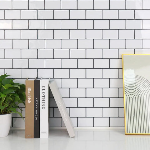 Thick Peel And Stick Backsplash Tiles In White Subway Style For Kitchen 10 Sheets Of 12 By 12 Inches 2mm To 2.5mm Thick Durable Self Adhesive DIY Friendly Easy Install Covers 40 Percent More Area shown on a wall with books and a plant.