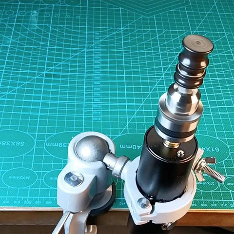 Close-up of the Rock Solid Workhorse Electric Leather Burnisher And Bench Polish Machine featuring the dual voltage clamp design on a green cutting mat.