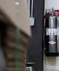 Heavy Duty Stored Pressure Water Fire Extinguisher Two Point Five Gallon For Class A Fires installed on wall in shop