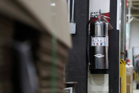 Heavy Duty Stored Pressure Water Fire Extinguisher Two Point Five Gallon For Class A Fires installed on wall in shop