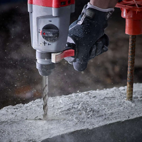 Close-up: rotary hammer drill with an SDS-Plus masonry bit drilling into concrete; 4-piece set 6/8/10/12 mm