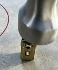 Close-up of a metal tool pressing into a surface with marked red circle, not related to Self Drilling Drywall Anchors and Screws Kit image