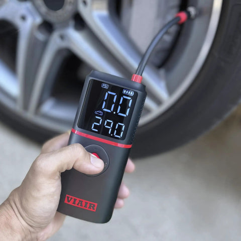 Slick Rechargeable Tire Inflator And Portable Air Compressor Featuring Digital Led Display and Automatic Shutoff in hand.