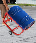 Person using Rock Solid 55 Gallon Drum Cradle Heavy Duty Steel Drum Stand with blue drum on smooth rolling lockable caster wheels.