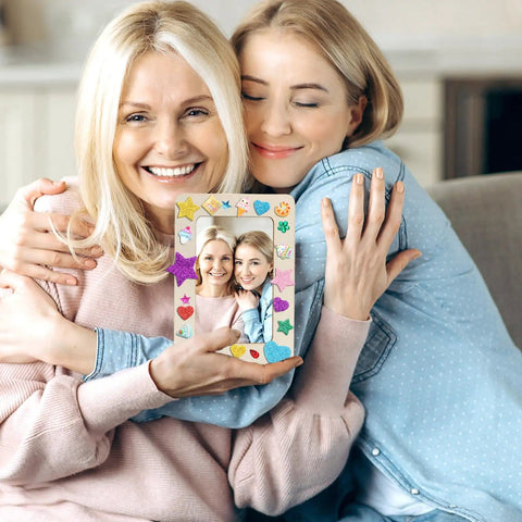 Two women holding a decorated frame from DIY Wooden Picture Frame Craft Kit With 24 Blank Frames, Paint Set With 12 Colors And 2 Brushes
