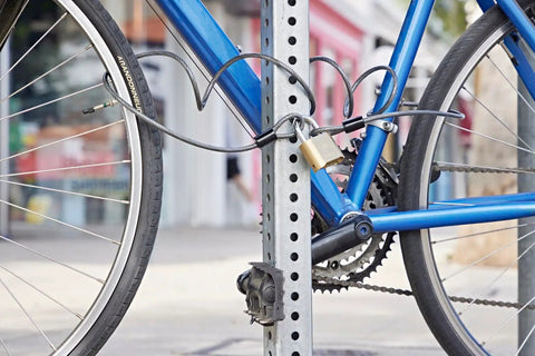 Bicycle secured with Beefy Heavy Duty Flexible Steel Loop Cable With Vinyl Coated Wrap For Corrosion Protection Six Feet Long Quarter Inch Diameter Gray Finish 1500 Pound Break Strength Great For Securing Gear And Equipment on a metal post.